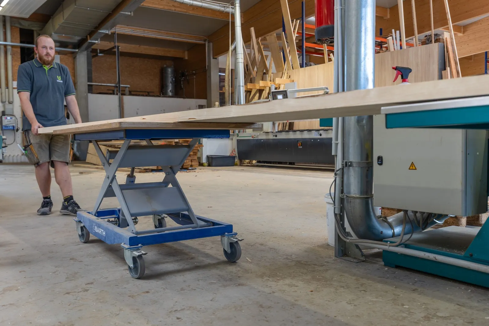 Ein Schreiner arbeitet an einem Hubtisch der Firma BARTH in einer Schreinerei in Bayern.